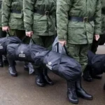 Російські солдати в камуфляжі тримають чорні сумки з написом Армія Росії