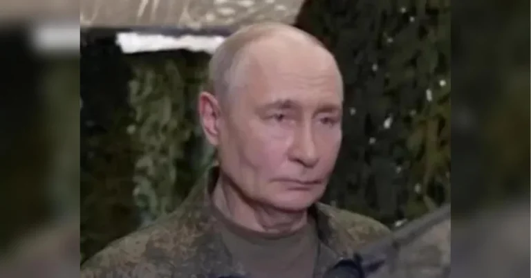 Володимир Путін у камуфляжній куртці на тлі зеленої маскувальної сітки