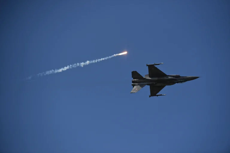 Винищувач F-16 у синьому небі запускає ракету з димовим слідом