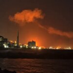 Нічна пожежа і помаранчевий дим над портовими будівлями Махачкали біля води