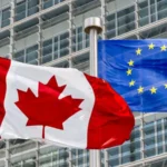 Прапори Канади та ЄС майорять перед скляною сучасною будівлею