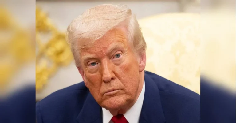Дональд Трамп у синьому костюмі з червоною краваткою дивиться серйозно