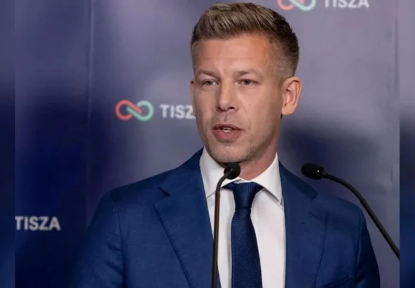 Петер Мадяр у синьому костюмі виступає біля мікрофонів на тлі логотипу TISZA