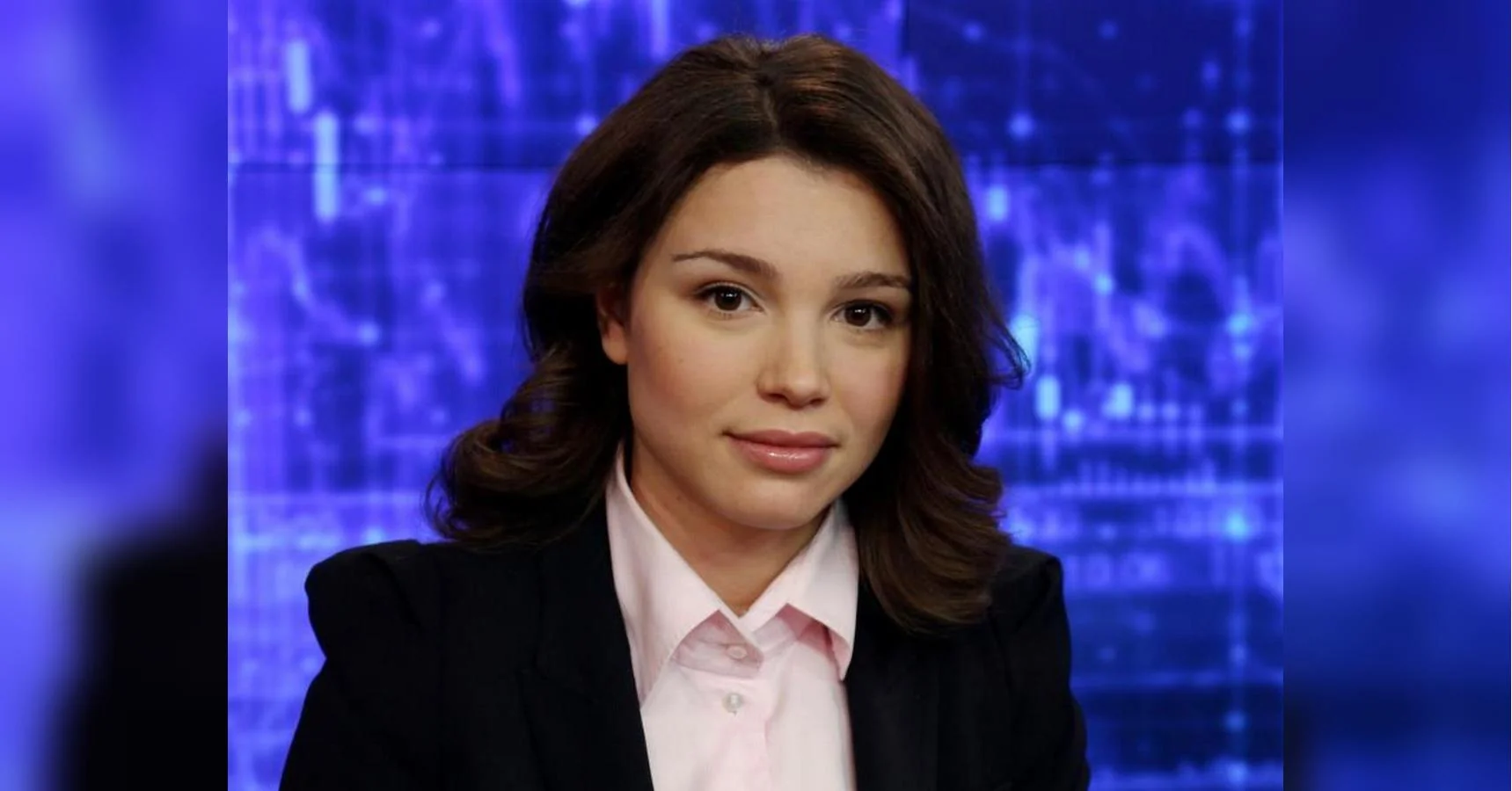 Жанна Нємцова в чорному піджаку та рожевій сорочці на тлі телестудії