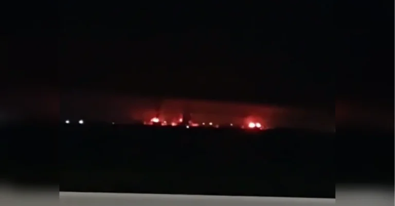 Нічне небо з червоним світінням пожеж і димом на горизонті