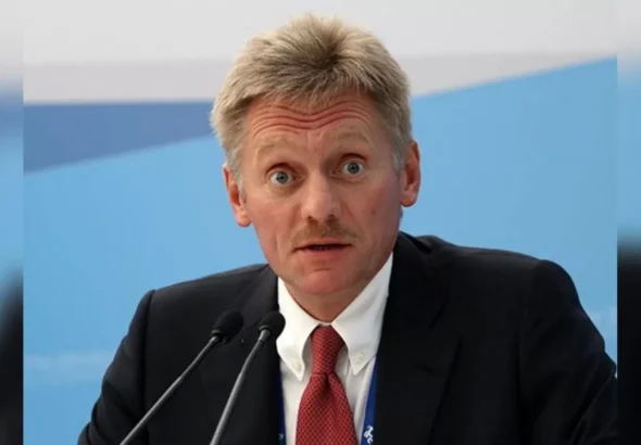 Дмитро Пєсков у костюмі говорить у два мікрофони на пресконференції
