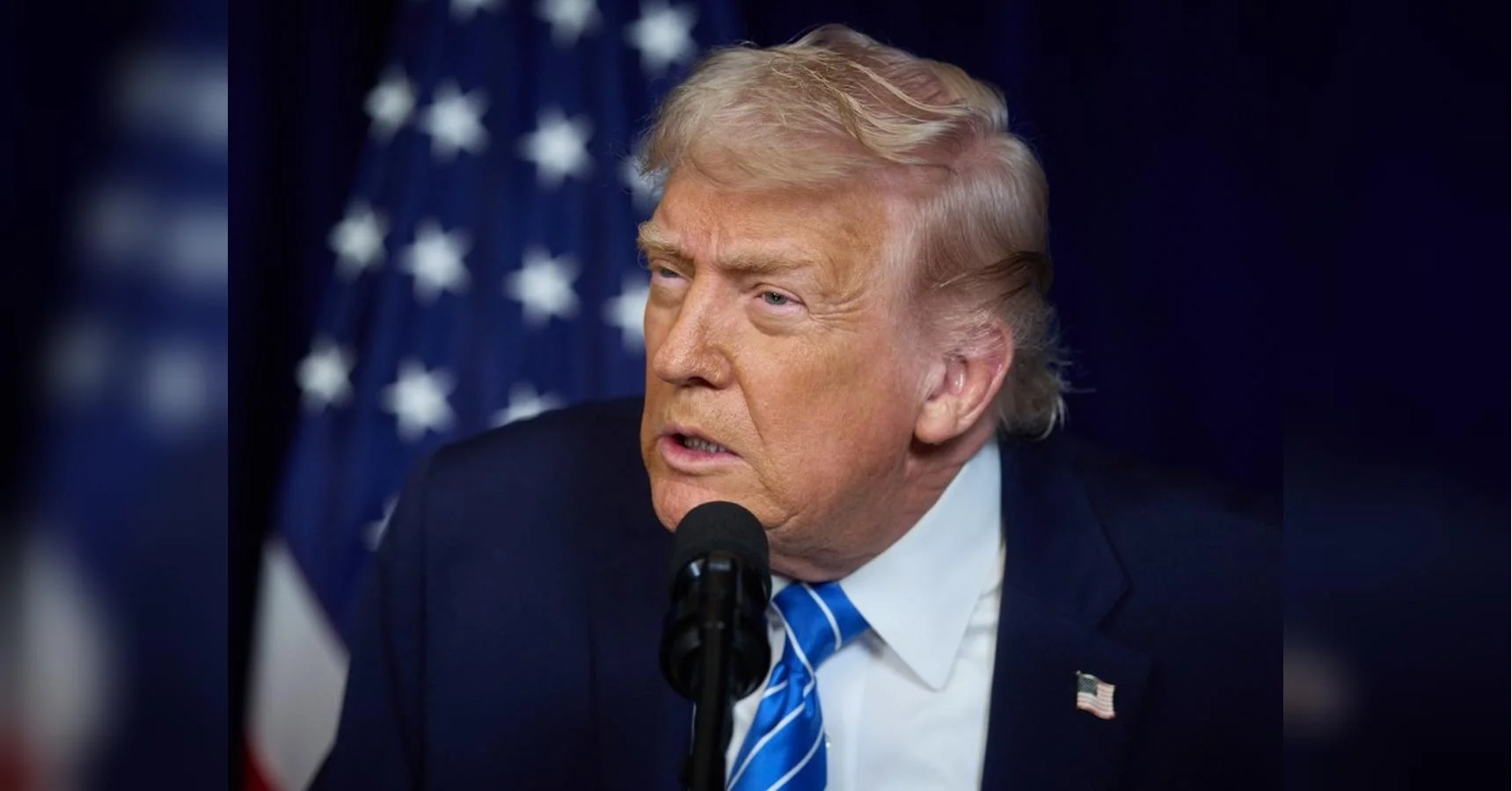 Дональд Трамп виступає перед мікрофоном на тлі американського прапора