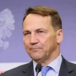 Радослав Сікорський говорить у мікрофон на тлі польського білого орла