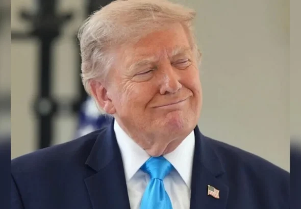 Дональд Трамп у темно-синьому костюмі й блакитній краватці посміхається