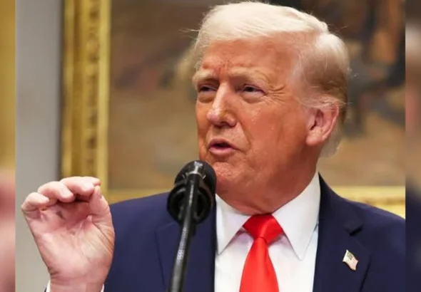 Дональд Трамп у синьому костюмі говорить у мікрофон і жестикулює рукою