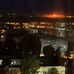 Нічний Київ: багатоповерхівки в темряві та велика пожежа на горизонті