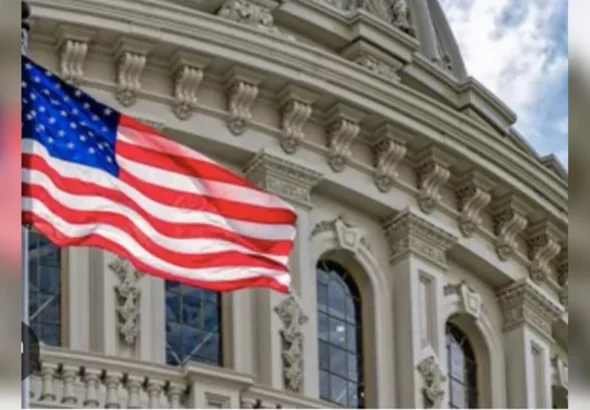 Прапор США майорить перед орнаментованим фасадом урядової будівлі з арками