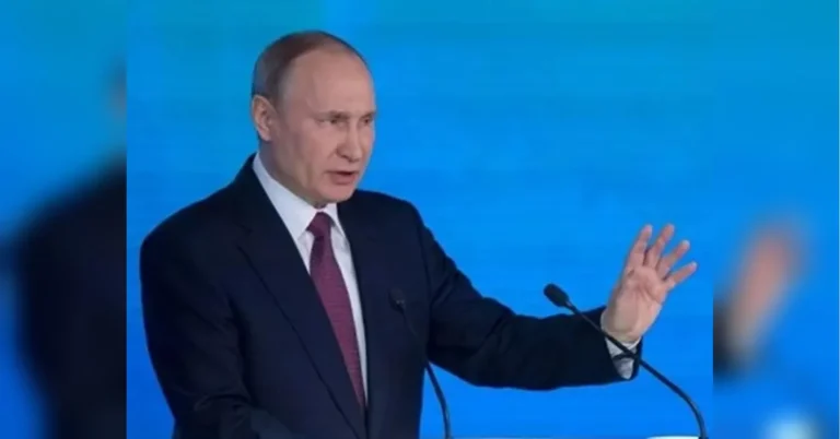 Володимир Путін виступає на трибуні з мікрофонами на синьому тлі